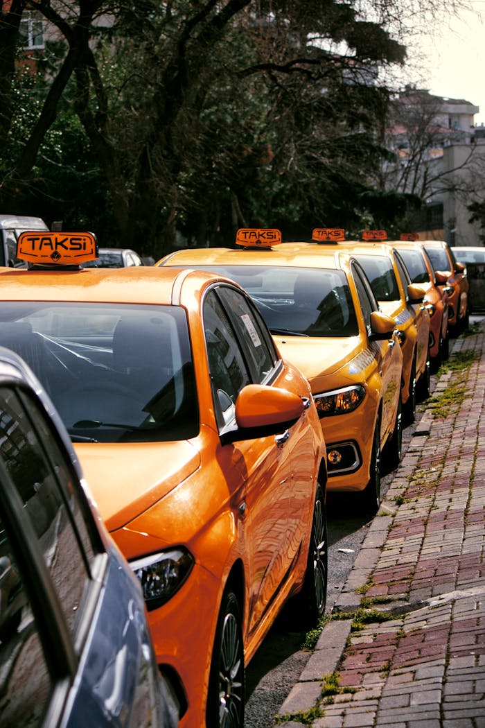 Close-up of multiple yellow taxis on a cobblestone street, hinting at lively urban transportation.